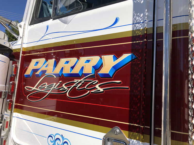 Parry Logistics lettering in blue and cream script on a maroon truck