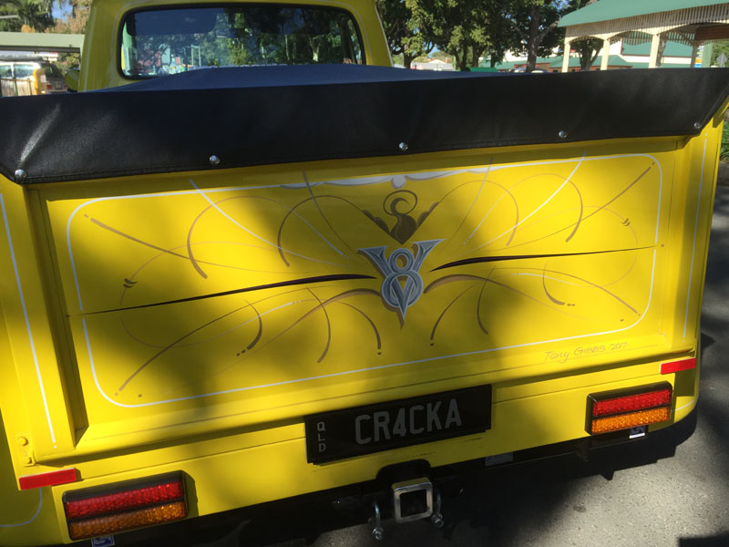 Pinstriped emblem on the yellow tailgate of a ute