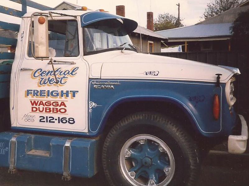 Older photo of a white and blue International truck with a hand-lettered door reading Central West Freight, Wagga Dubbo
